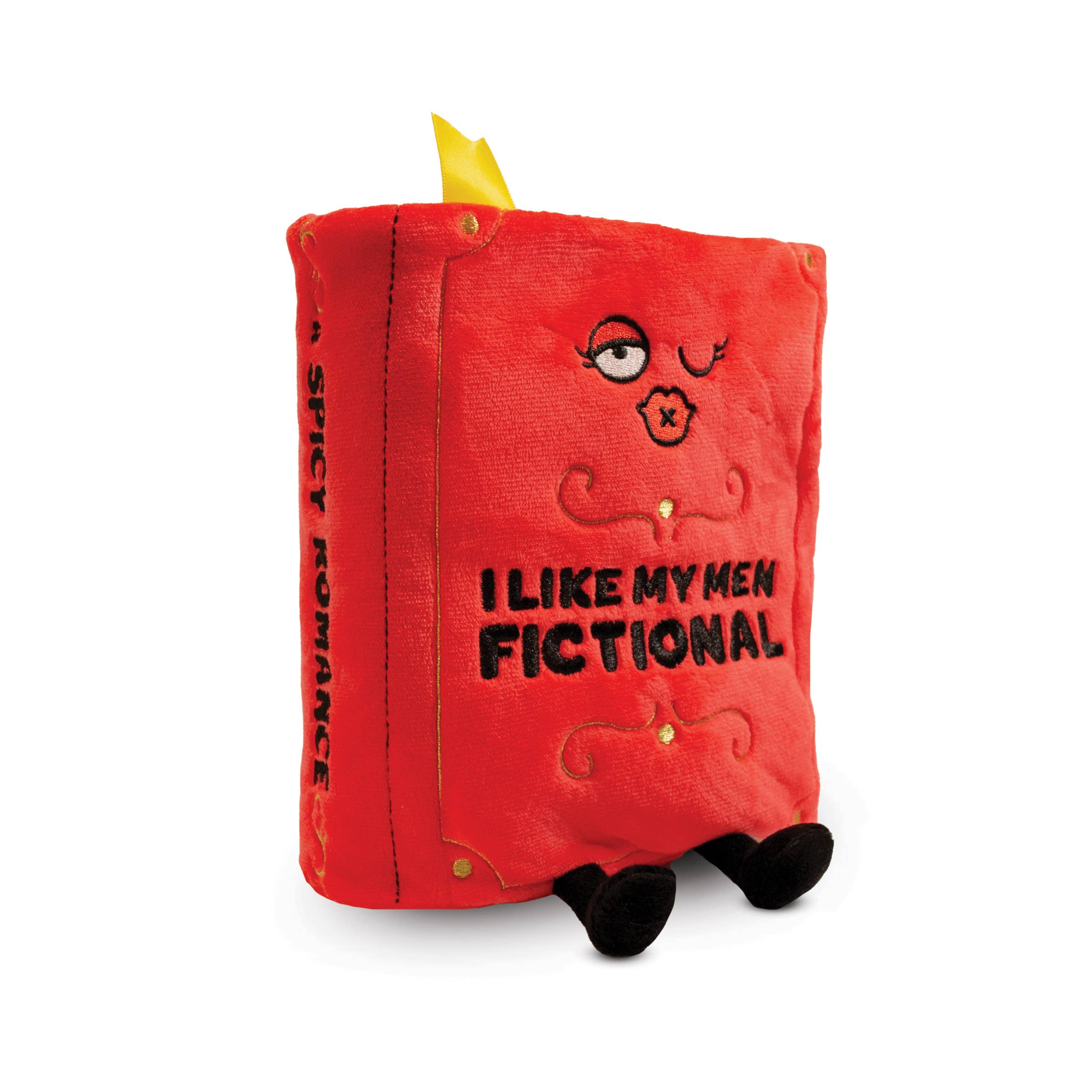 A red plush book with a kissy winky face and embroidered black text that reads 'I like my men Fictional.' The plush has black legs sticking out, a yellow bookmark peeking from the top, and 'A Spicy Romance' embroidered in black on the book's spine.