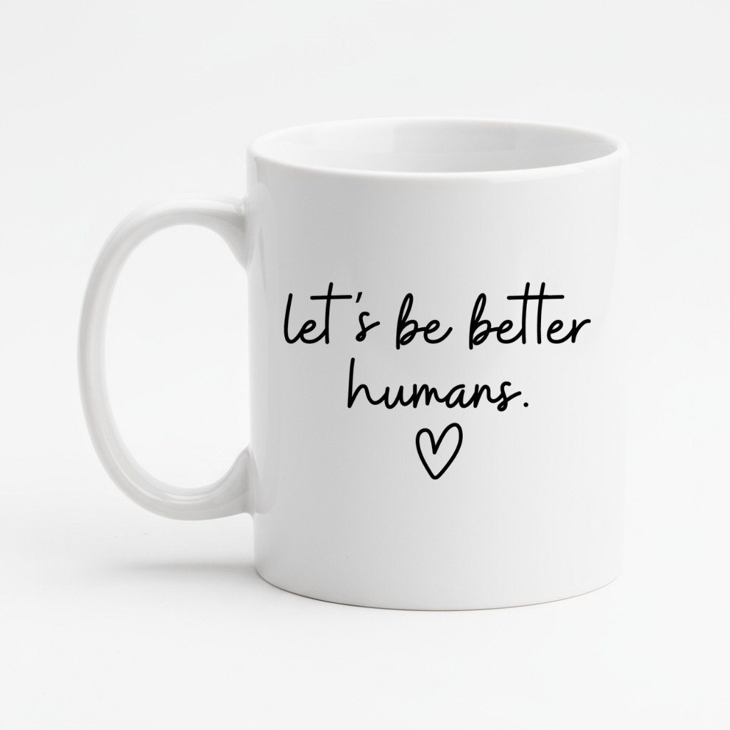 White mug with 'let's be better humans' text and heart symbol on a white background