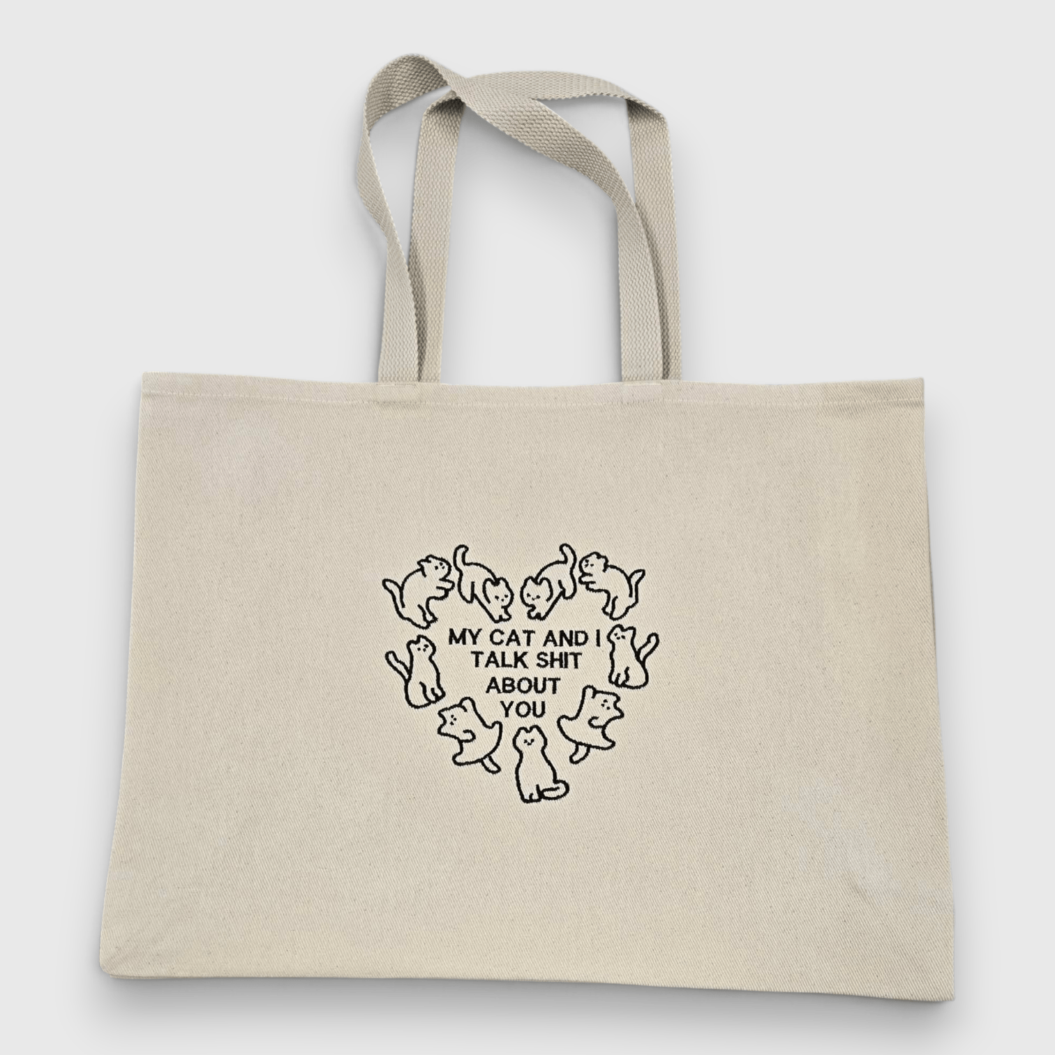 Embroidered Tote with cats around a heart shape with the words "My cat and I talk shit about you"