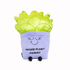 A soft, plush plant toy featuring a vibrant green plant in a purple pot. The purple pot has a cheerful, smiling face with closed eyes, and black text on the front reads 'Proud Plant Parent.'