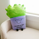 A soft, plush plant toy featuring a vibrant green plant in a purple pot. The pot has a cheerful, smiling face with closed eyes, and black text on the front reads 'Proud Plant Parent.'