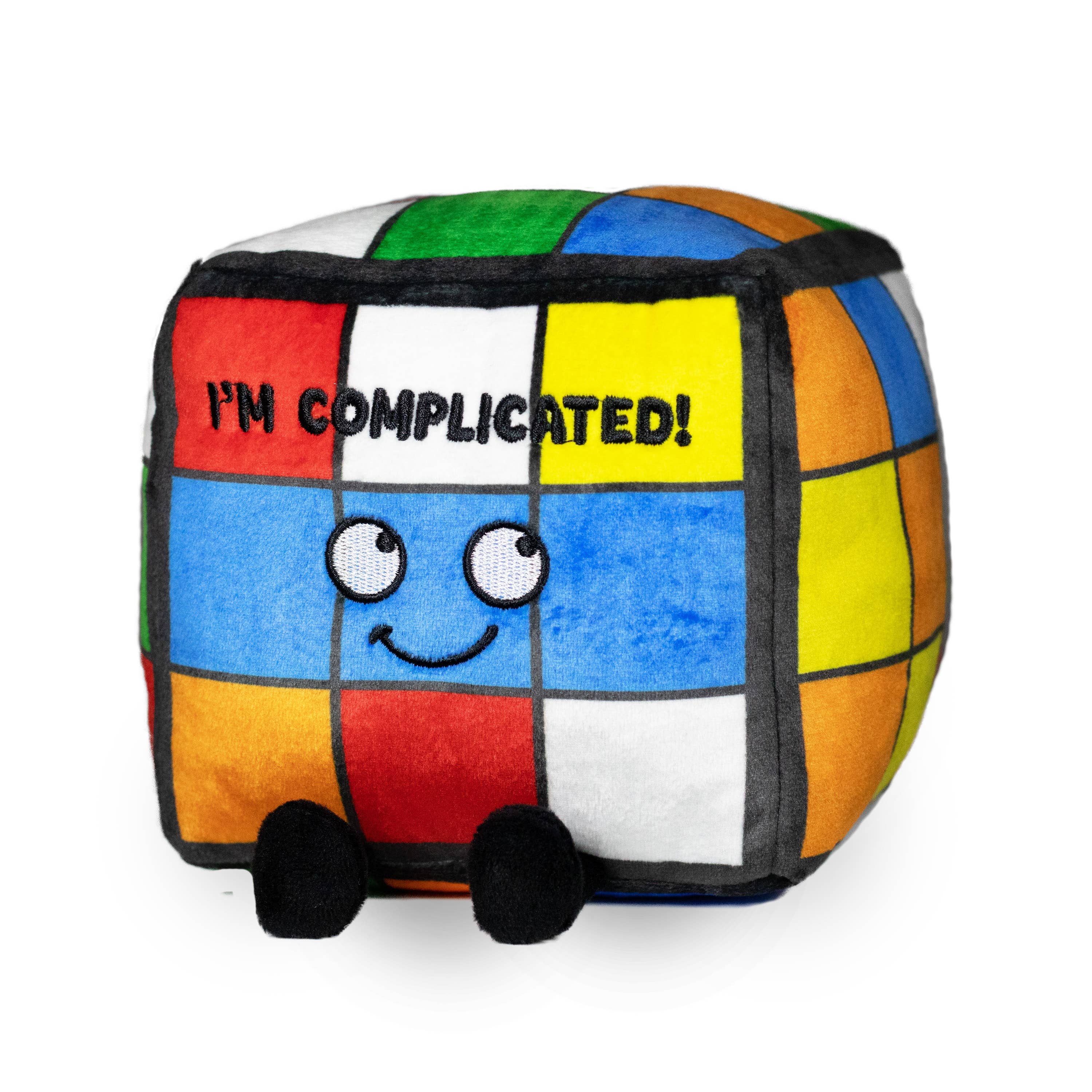 A rainbow puzzle cube plushie with a smiley face and black text that says "I'm complicated." The plushie has black legs sticking out.