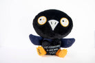 A black and blue raven plushie with a white beak and white and yellow eyes. Its wings are holding a black heart with the white text "Nevermore in love with you." The raven has yellow legs with a black "xoxo" on the right foot.