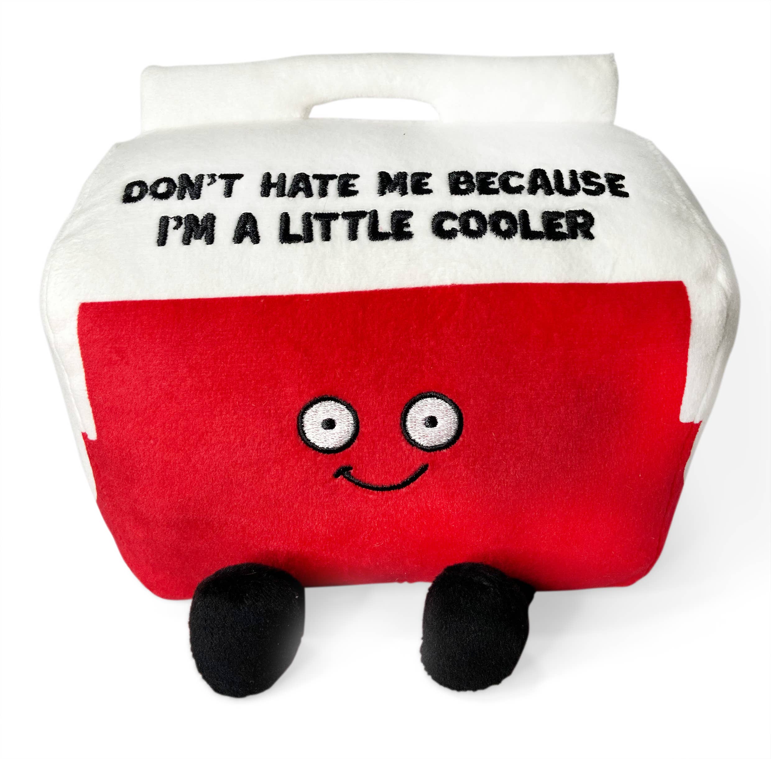 A cooler plushie with a white top and red bottom. The white top features black embroidered text that says, "Don't hate me because I'm a little cooler." The red section has a smiling face, with black legs sticking out from the bottom.