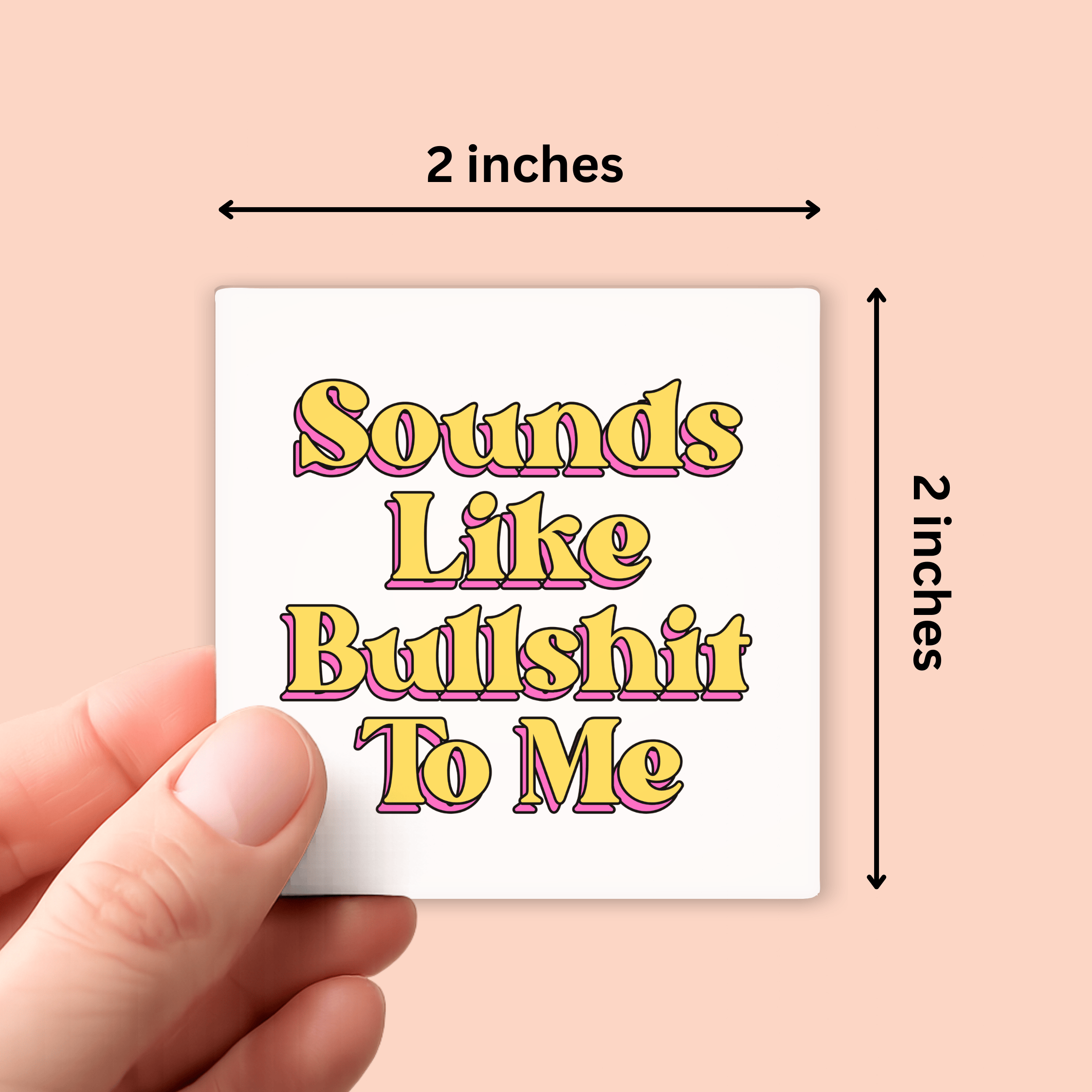 A hand holds a small square white sticker against a peach background. The sticker has retro-style yellow and pink text reading 'Sounds Like Bullshit To Me.