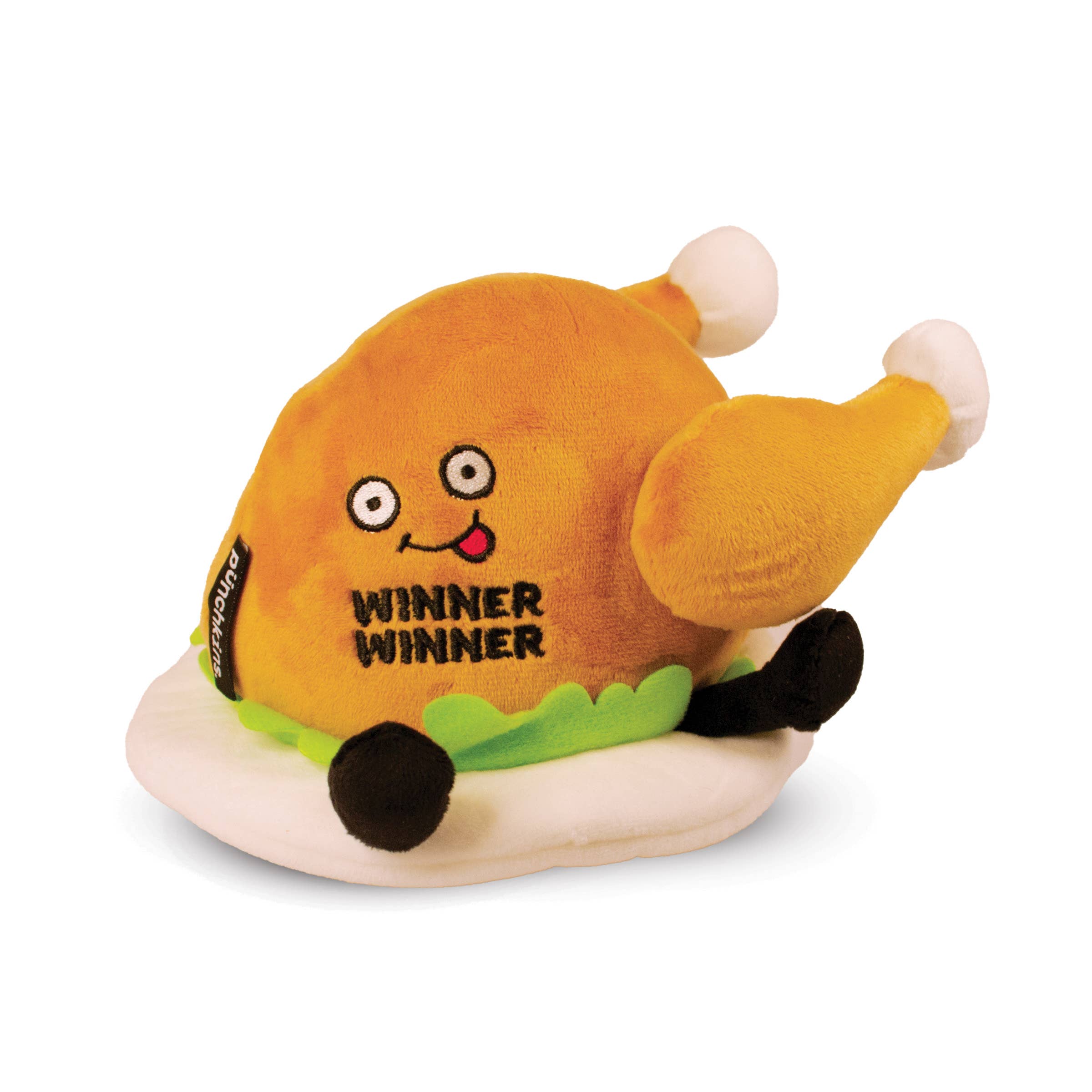 A cooked turkey dinner plush on a plate with green lettuce. The turkey has a smiley face with a red tongue sticking out and black text that says "Winner Winner." It also has black legs sticking out.