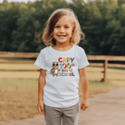 Child wearing a t-shirt celebrating the 100th day of school outdoors.