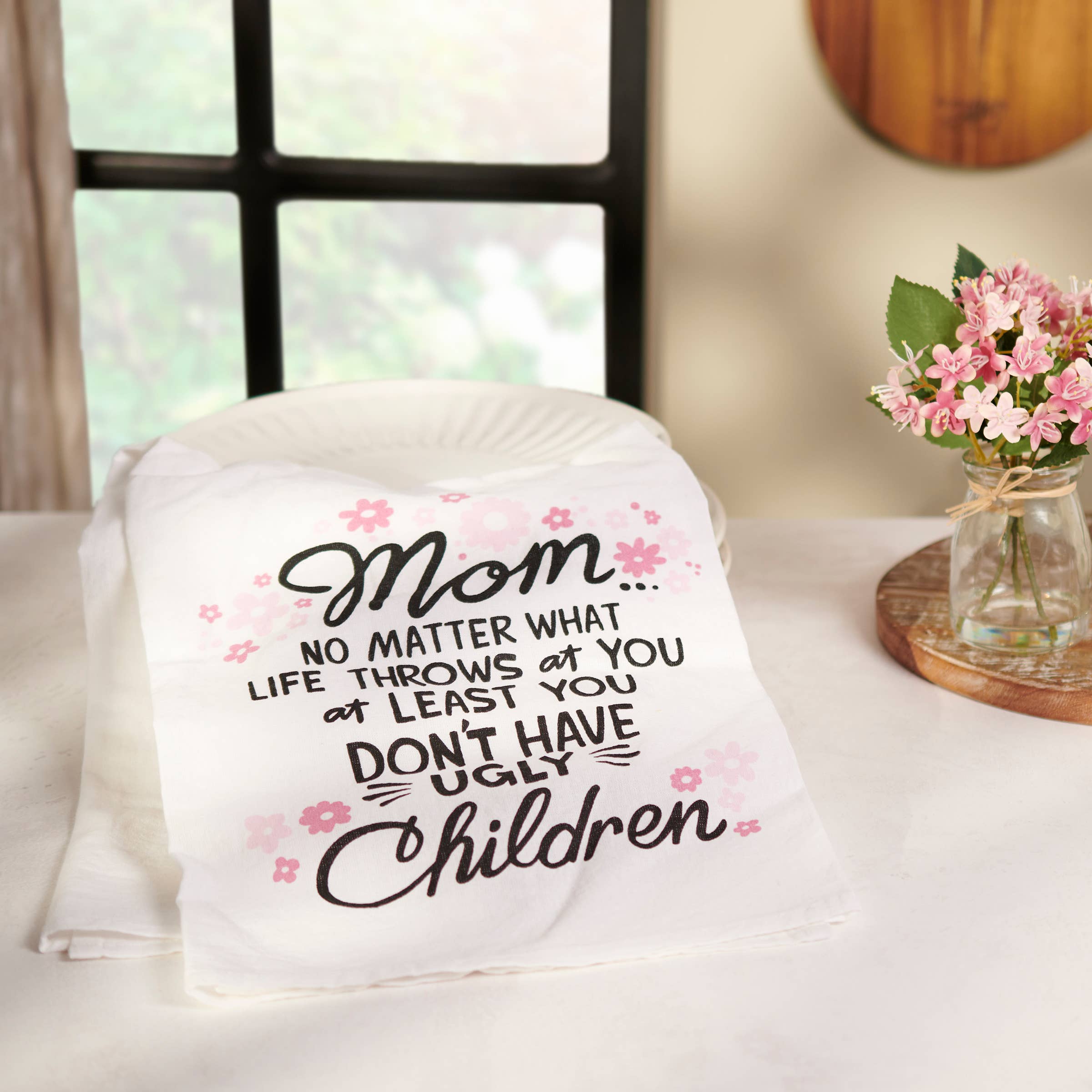 Blanket with humorous text on a table with a vase of flowers in the background