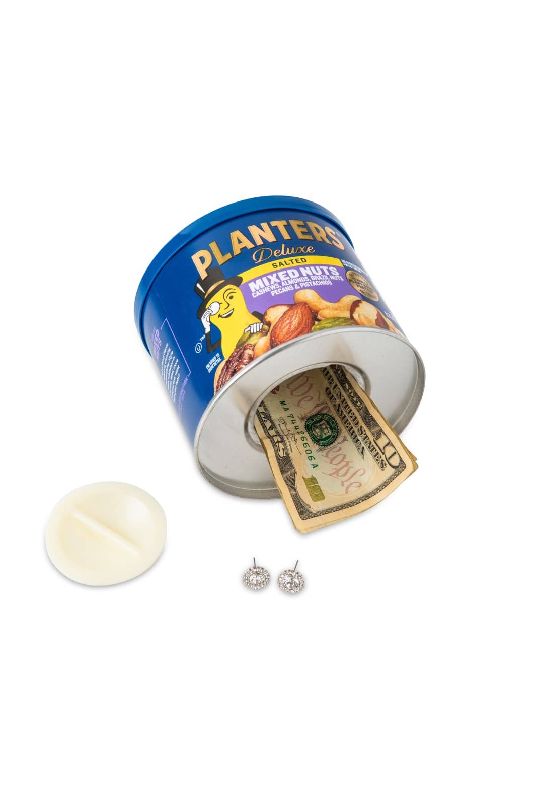 A blue Planters mixed nuts can is open on its side, revealing cash inside. Nearby are a white lid and a pair of diamond earrings, suggesting hidden storage.