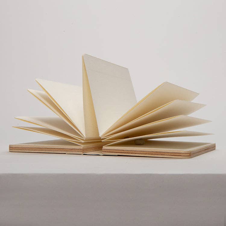 Accordion-style flower press opened flat, showing layered blotting paper pages between wooden covers.