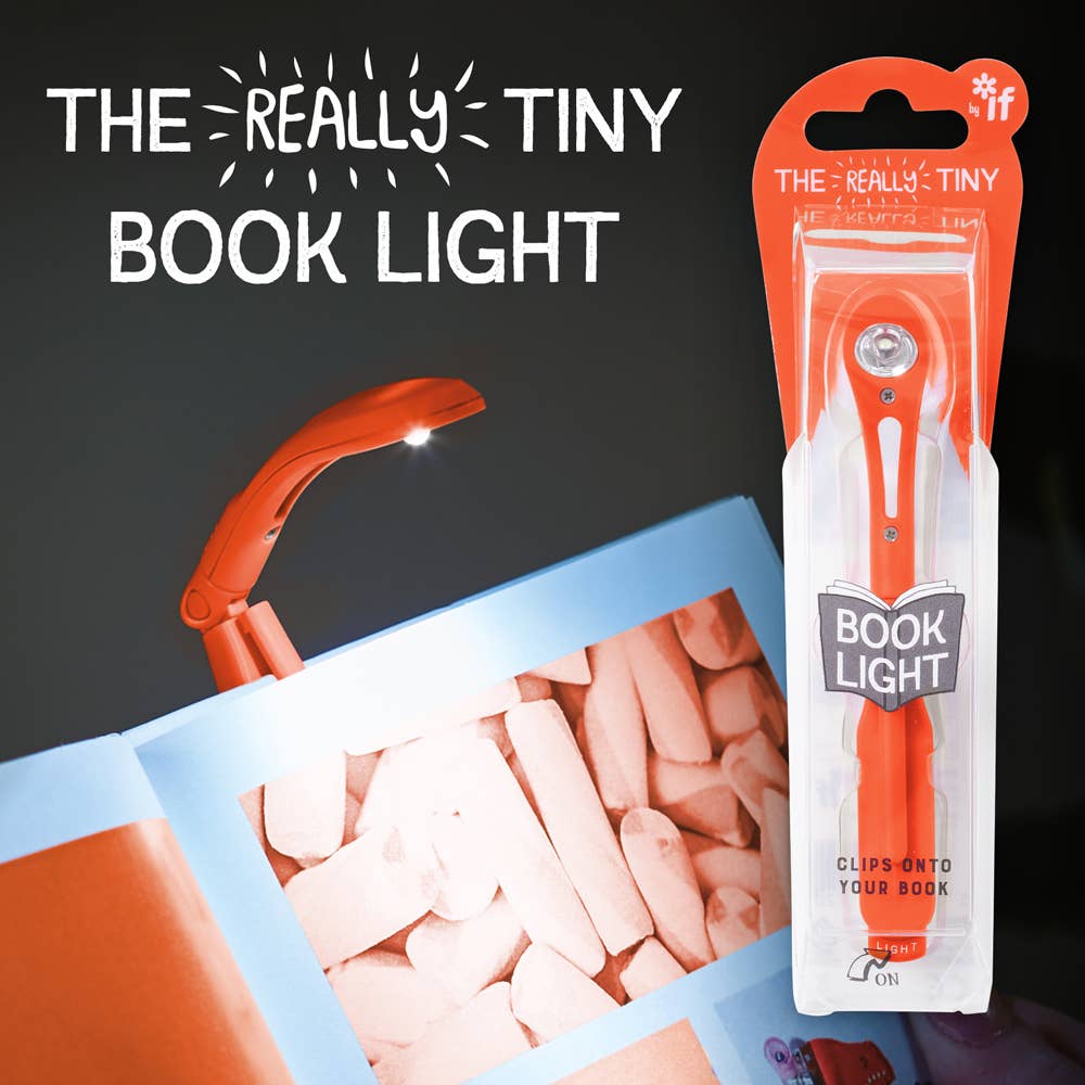 A small, orange book light is clipped to an open book, illuminating the pages. Packaging on the right showcases "The Really Tiny Book Light" branding.