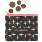 A small pouch with pink zipper and star pattern, featuring the text "I'm not needy, I'm wanty." Five U.S. coins are placed above the pouch.