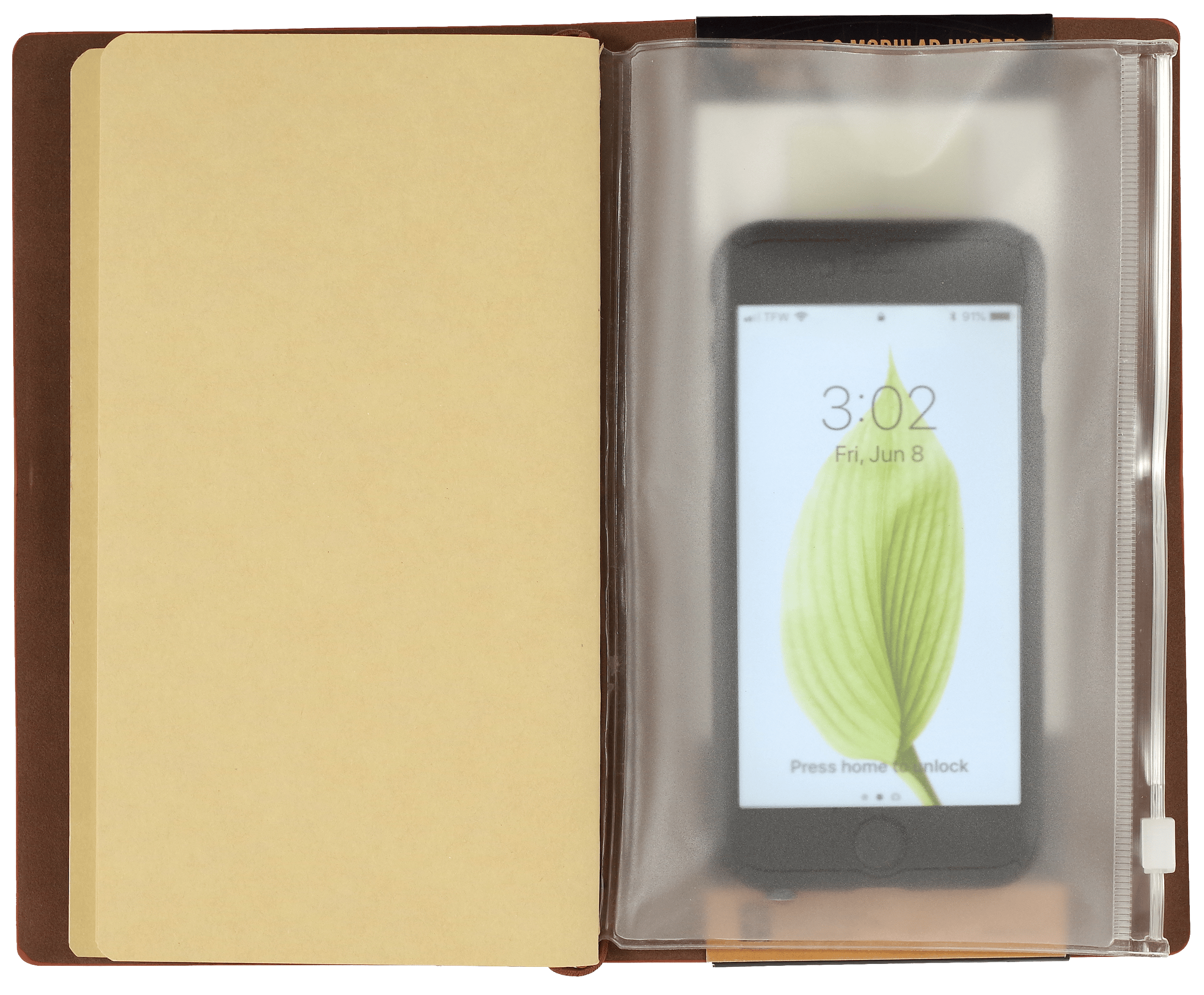 Open notebook with a beige page on the left and a smartphone inside a clear plastic sleeve on the right. The phone displays a leaf on its lock screen.