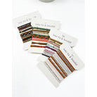 Assorted sets of colorful hair ties and bracelets on white packaging cards labeled "hair tie & bracelet," showcasing various textures and patterns.