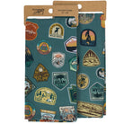 Two kitchen towels with nature-themed patches in packaging on a white background