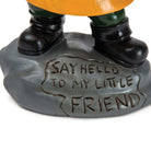 A statue's feet in black boots stand on a gray base with engraved text "Say hello to my little friend," conveying a playful tone.