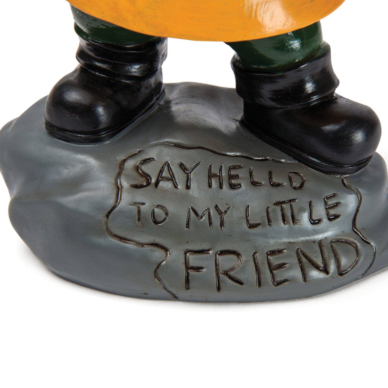 A statue's feet in black boots stand on a gray base with engraved text "Say hello to my little friend," conveying a playful tone.