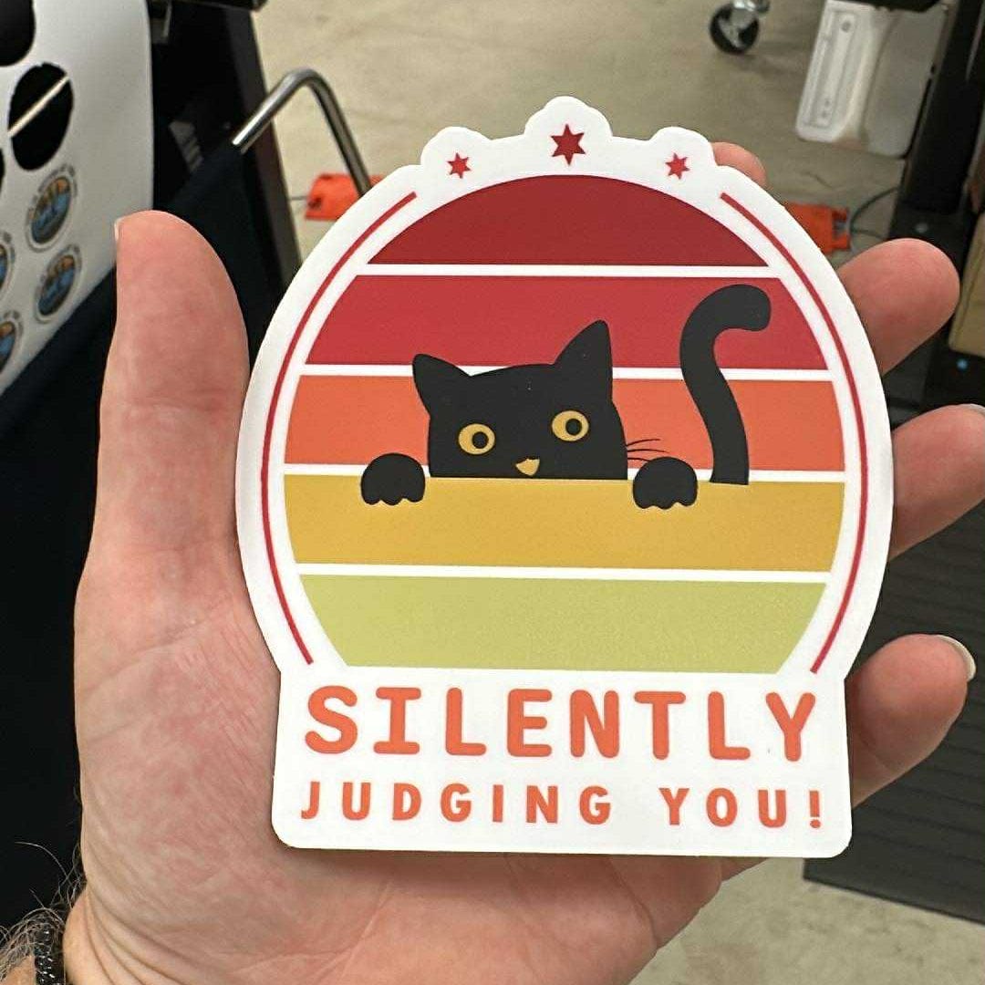 sticker with a cat design and text 'Silently Judging You!' 