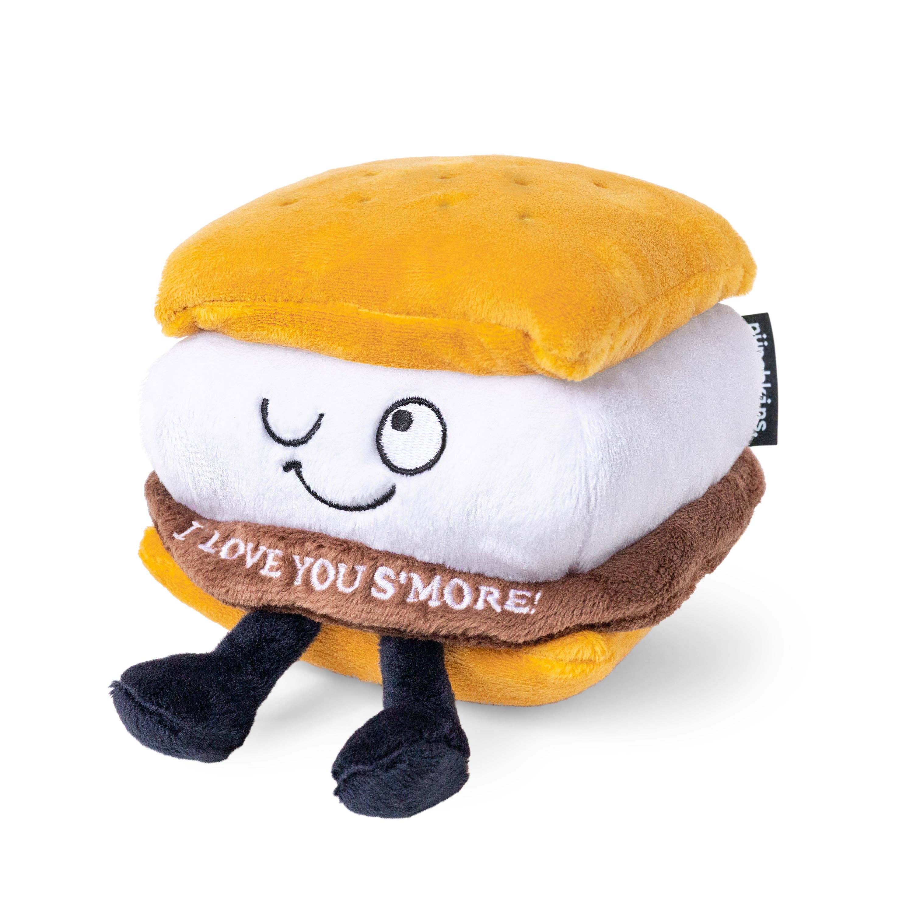 A plushie shaped like a s'more with a winky face. The chocolate layer features white lettering that reads "I love you s'more!"