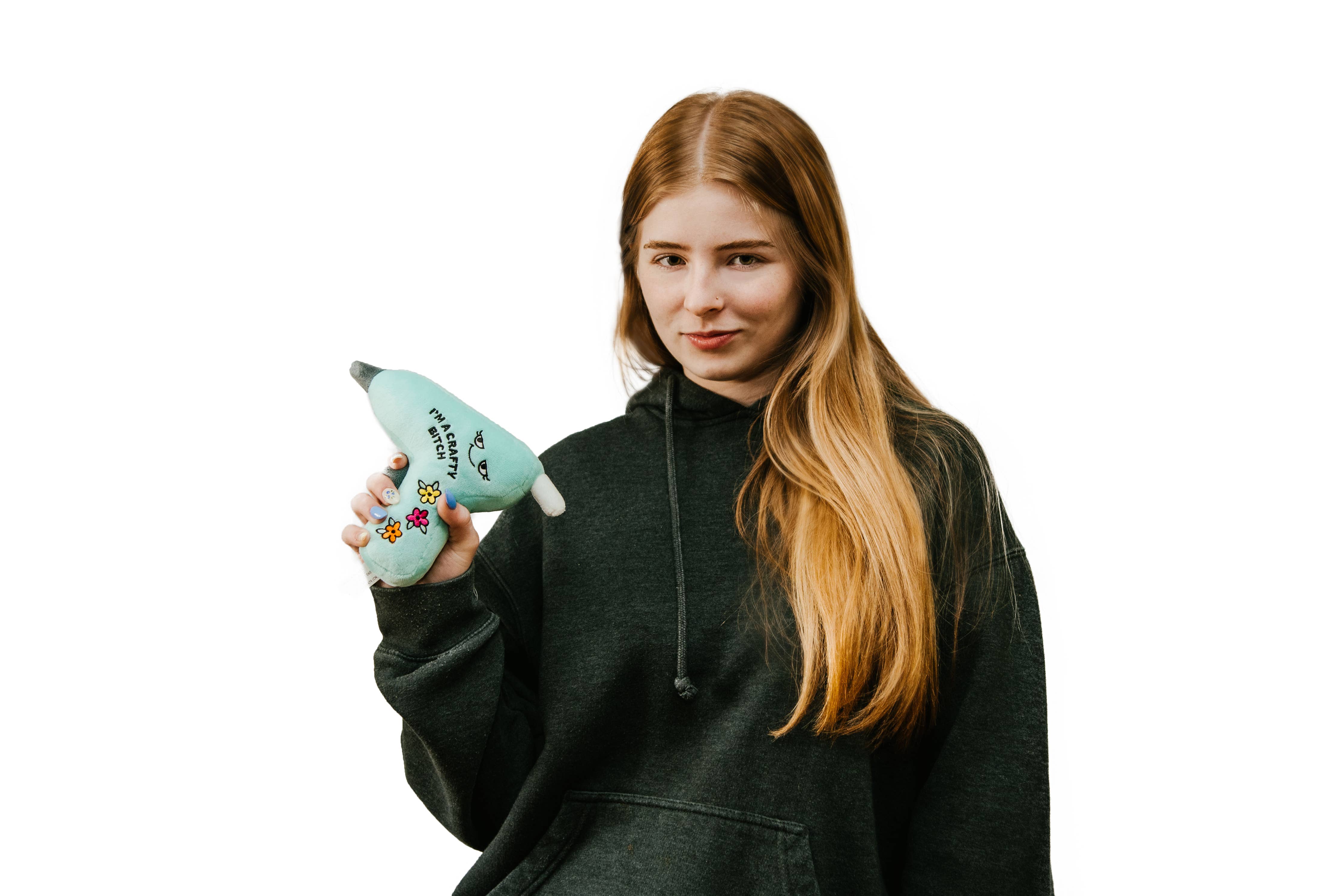 woman holding A blue glue gun plushie with a smiley face, three flowers, and black embroidered text that says 'I'm a crafty bitch.