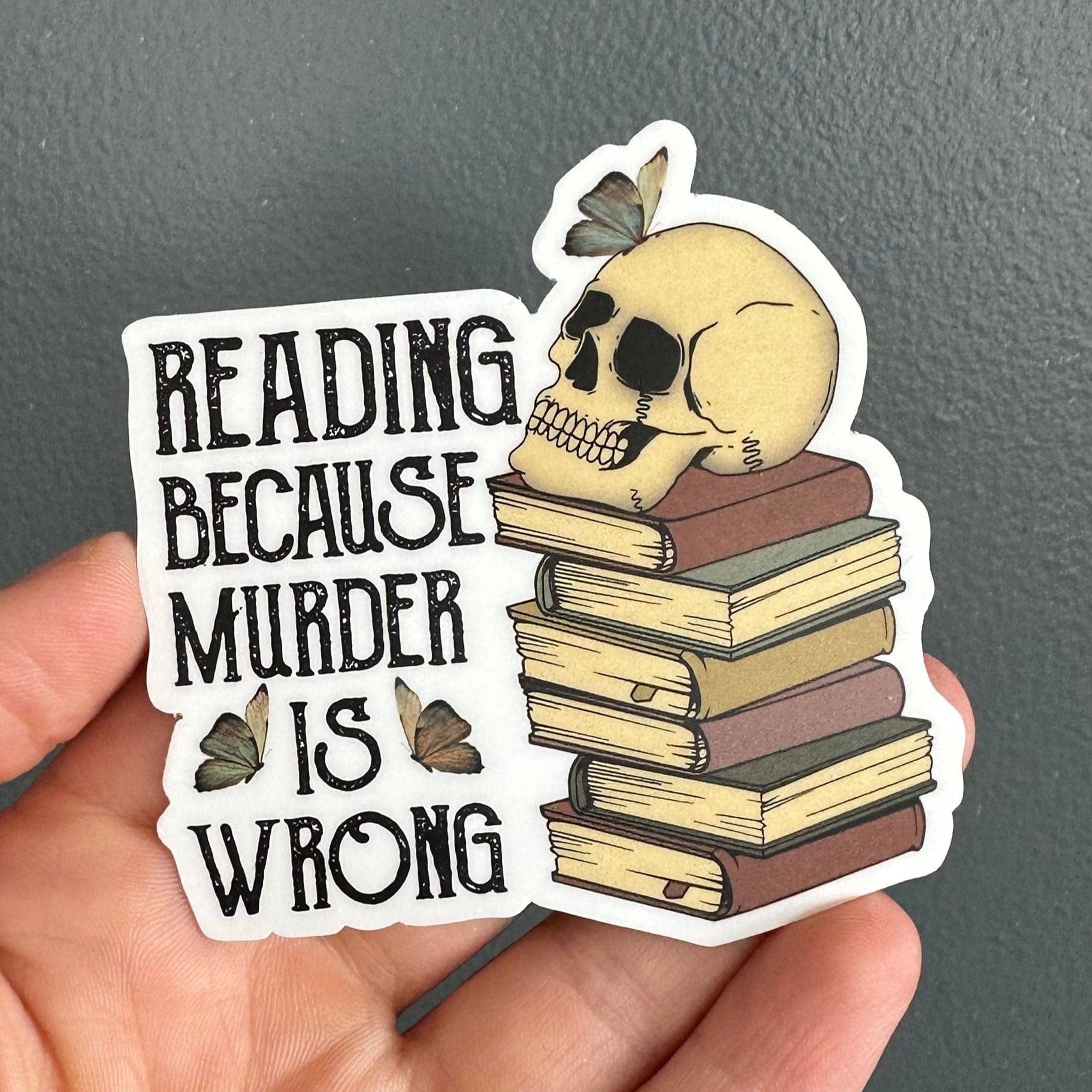 Sticker that says "reading because murder is wrong" next to a stack of books with a skeleton sitting on top.