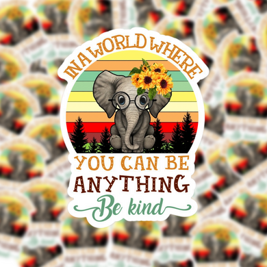 In a World Where You can be anything, be kind.  This cute elephant with glasses and sunflowers sits in front of a retro sunset background.